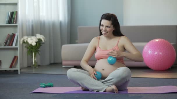 Žena, která dělá masáž na bříšku s dítětem uvnitř s malým fitness míče — Stock video
