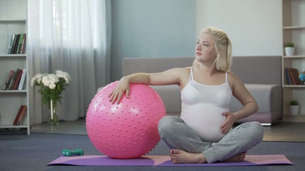 Zwangere vrouw te denken over de charmes van het moederschap teder het aanraken van haar buik — Stockvideo