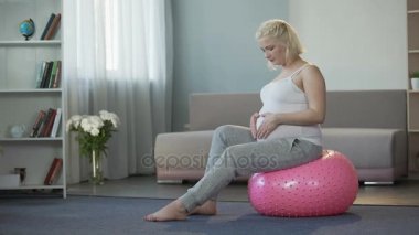 Yavaşça karın okşayarak zevk ve gebelik ile sevindirici mutlu gelecekte anne