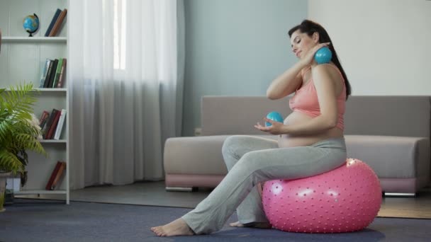 Schwangere massiert ihren Körper und bekommt Freude an speziellen Fitness-Bällen — Stockvideo