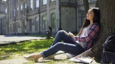 Sakince Kapalı gözlerle, gevşeme ağacın altında oturan çok uluslu genç kadın