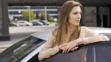 Hoş bir Bayan araba mevcut ve kamera için poz zevk. Mutlu kadın ve otomatik