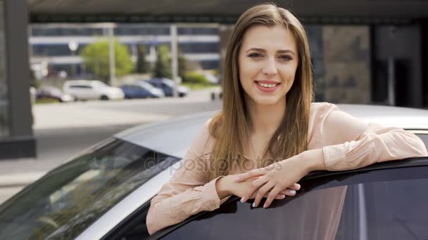 Mulher bonita que está perto de auto e posando para a câmera. Comprar um carro — Vídeo de Stock