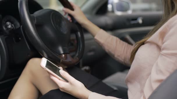 Mujer de negocios sentada en el coche y noticias de desplazamiento en el teléfono inteligente, aplicación móvil — Vídeos de Stock