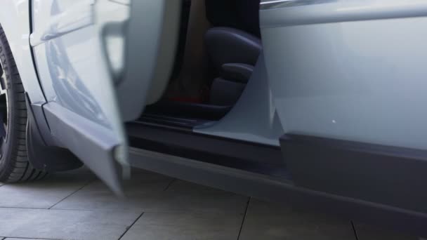Женская модель в красных туфлях на высоком каблуке, сидящая на водительском сиденье в машине — стоковое видео