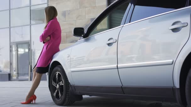 Довольно грустная женщина стоит рядом с автомобилем и ждет парня, одиночество — стоковое видео