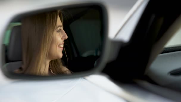Szczęśliwa kobieta-kierowca siedzi w samochodzie i rozmawiać z chłopakiem, lusterko wsteczne — Wideo stockowe