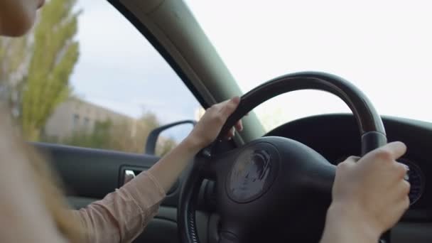 Uma mulher a conduzir veículos na cidade. Mãos femininas a virar o volante. Tráfego — Vídeo de Stock