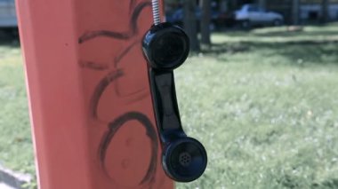 Ankesörlü telefon alıcısı uzayda sallanıyor, bitmemiş telefon görüşmesi, suç ilişkisi