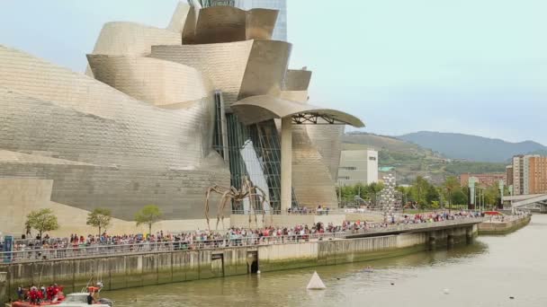 Persone riunite sul lungofiume, scultura di ragni davanti al museo Guggenheim — Video Stock