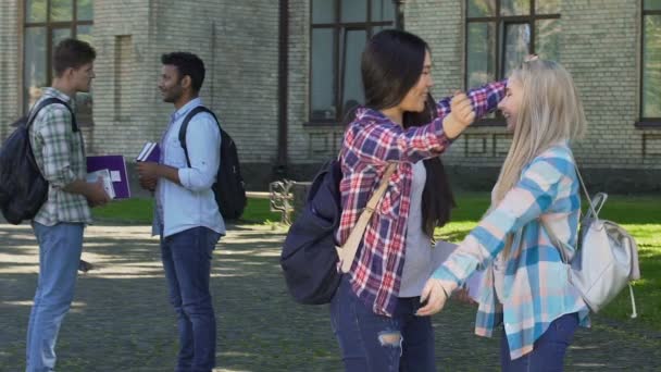 Two multiracial females congratulating each other on successful test and hugging — Stock Video