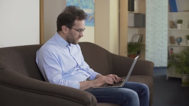 Hombre serio con portátil pensando cómo hacer dinero extra, las tecnologías modernas — Vídeo de stock