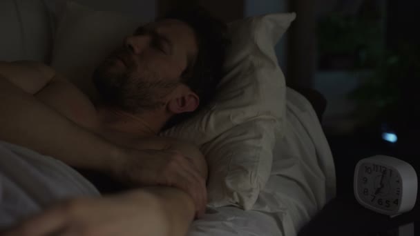 Sabah erkenden, dönüm uykulu yetişkin adam zil çalar saat — Stok video