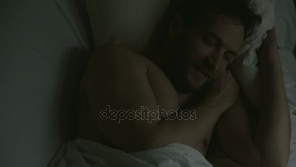Спокойный сон красивого взрослого мужчины, лежащего в постели, улыбающегося во время сна, расслабляющегося — стоковое видео