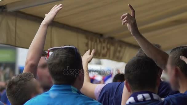 Болельщики из Франции аплодируют и смотрят футбольный матч в фан-зоне — стоковое видео