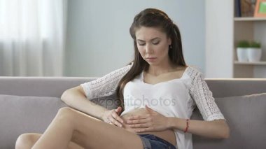 Kanepe ve hissi mide, üzerinde oturan Anne-olmak endişeli, seyir rahatsızlık