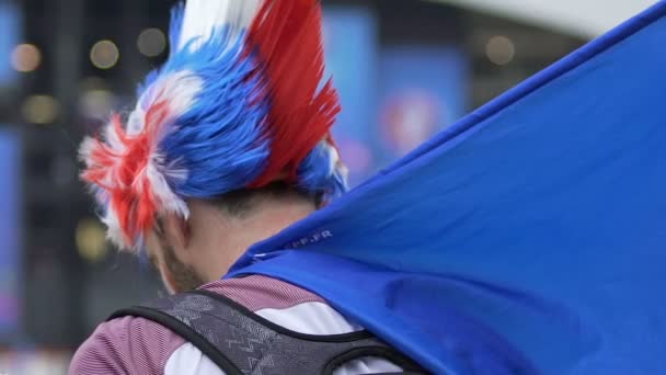 Voetbalfan uit Frankrijk grappige haan hoofddeksel dragen en wachten op wedstrijd — Stockvideo