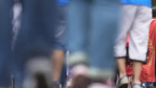 Нижний вид футбольных болельщиков ноги прогулки по переполненной улице, чемпионат — стоковое видео