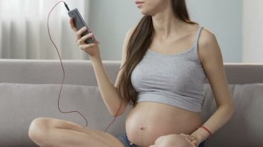 Koltukta oturan kadın müzik yatıştırıcı cep telefonu, şarkı seçme bekliyor