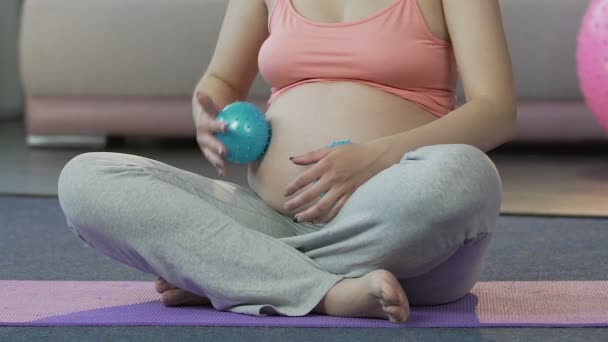 Kobieta spodziewa się przez żołądek, krocząca piłki do masażu relaks terapia, Pielęgnacja ciała — Wideo stockowe