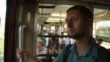 Açık hava metro sürme, grabrail tarafından holding ve vitrinlere bakıyor erkek yolcu