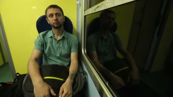 Κουρασμένη ανδρική κατόχων διαρκούς εισιτήριου κάθεται στο πόλησιδηροδρομικές από το σκοτεινό παράθυρο, επιστρέφουν στο σπίτι το βράδυ — Αρχείο Βίντεο