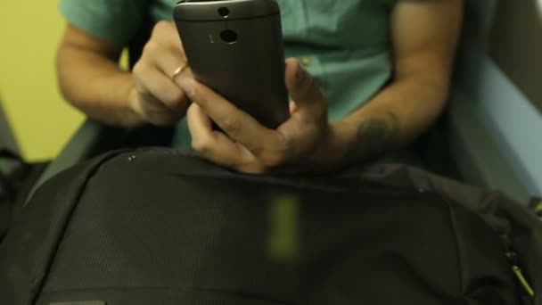 Homme assis par la fenêtre dans le train la nuit et tapant un message sur son téléphone portable — Video