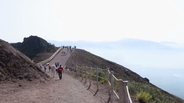 Naples, Italië - Circa juli 2014: Sightseeing in de stad. Toeristen verplaatsen langs wandelpad rond de Vesuvius de vulkaan, passeren van zijn scherpe kliffen — Stockvideo
