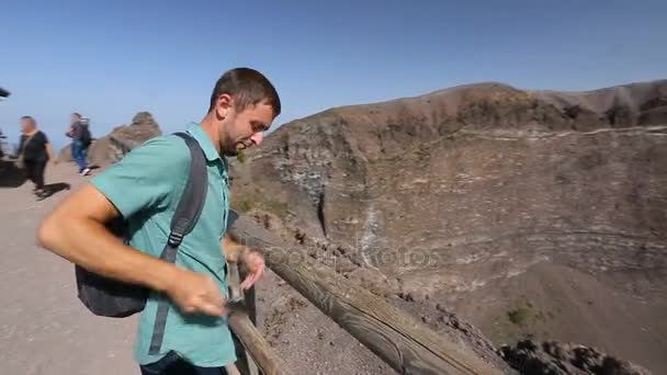 Excited man coming to observation deck edge on Vesuvius top take video of crater — Stock Video