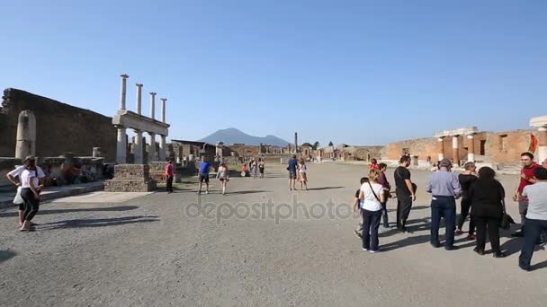 NAPLES, ITALIA - CIRCA JULIO 2014: Turismo en la ciudad. Grupo de turistas de pie en una espaciosa plaza en Pompeya, Templo de Júpiter en la parte posterior — Vídeo de stock