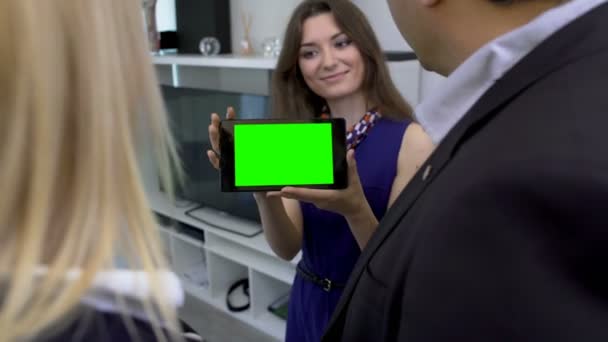 Lächelndes Mädchen zeigt Paarplan ihres neuen Hauses, Tablet mit grünem Bildschirm — Stockvideo