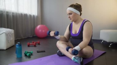 Obez kadın kolayca dumbbells ile kas bina kilo vermek istiyor