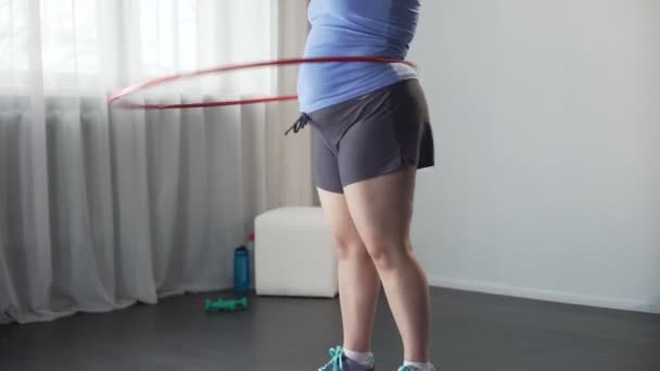 Menina obesa girando arco hula, sonho para remover o excesso de polegadas da cintura e quadris — Vídeo de Stock