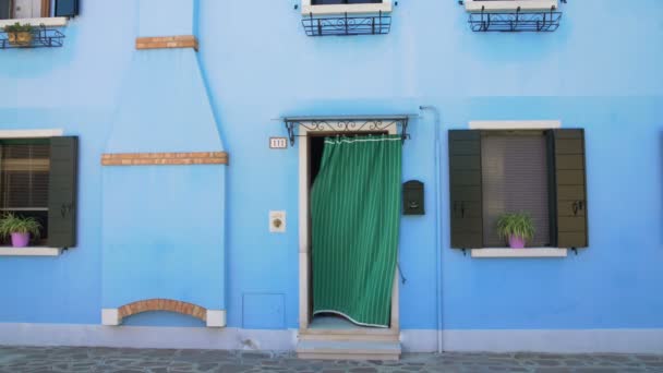 Schöne Aussicht auf ordentliches blaues Haus mit Blumentöpfen an den Fenstern, burano, venedig — Stockvideo