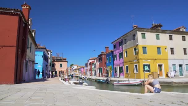 Vue fraîche sur les maisons colorées et le canal vénitien, les touristes se détendre à Burano — Video