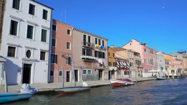 Na loďkách kanálu v Benátkách, pohled na útulné vícebarevné domy v Burano — Stock video