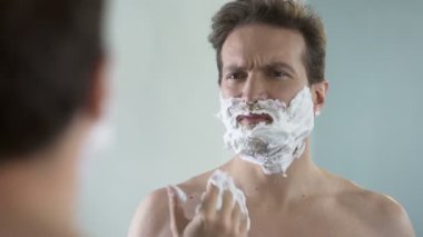 Tıraş hazırlanılıyor rahatsızlık hissediyor adam ve tıraş köpüğü yüzünden sızlamak