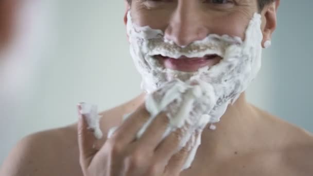 Pohledný muž spokojen s jeho novým produktem holení kvalitativní mužské kosmetiky — Stock video
