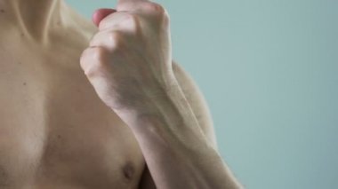 Yumruğunu kenetlenmesi ve pazı kameraya, erkeklik gösteren güçlü kişi