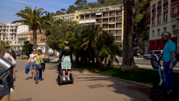 Nice, Franciaország - körülbelül 2016. június: Városnézés a városban. Lovaglás segways és sétálnak végig a tengerparti megtekintés platform, a turisták utazási — Stock videók