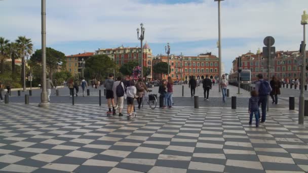 NICE, FRANÇA - CIRCA JUNE 2016: Passeios turísticos na cidade. Turistas despreocupados e moradores passeando ao longo do pavimento em mosaico da praça Massena — Vídeo de Stock