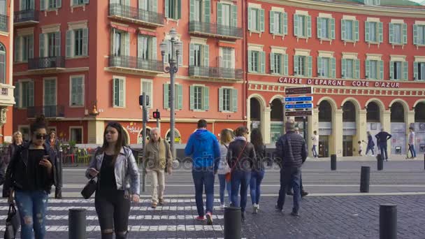 Nice, Frankrike - Circa juni 2016: Sightseeing i staden. Personer korsar gatan nära röda byggnaden av Caisse D'epargne Cote D'azur — Stockvideo