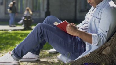 Genç adam dikkatle kitap empati ve ana karakterlerle endişesi okuma