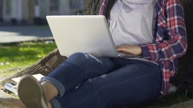 Üniversitesi bahçe içinde laptop ile oturmuş, sohbet online kız öğrenci