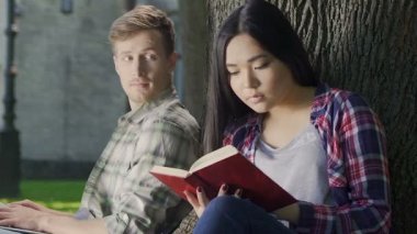 Hevesle sevgi dolu çocuklar fark etmeden heyecan verici kitap okuma biracial kız görünüyor