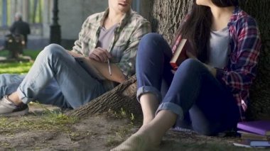 Romantik öğrenci kampüsünde, güzel bir kızla konuşmaya iyi kitabı tartışıyor