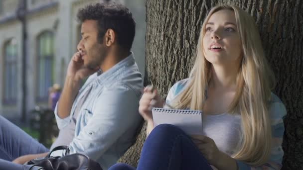 Killen som pratar telefon, hans flickvän komponera kärleksbudskap för honom, ungdom — Stockvideo