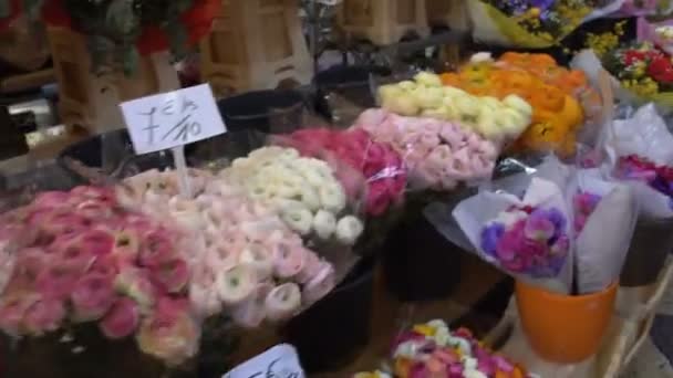 Koper wandelen langs lange markt rijen met kleurrijke boeketten van bloemen, winkelen — Stockvideo