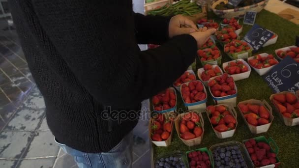 Hombre contando dinero para pagar a la vendedora por fresas frescas en el mercado local — Vídeo de stock