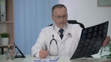 Deneyimli nörolog dikkatle inceleyerek beyin MRI, notes formunda yapma
